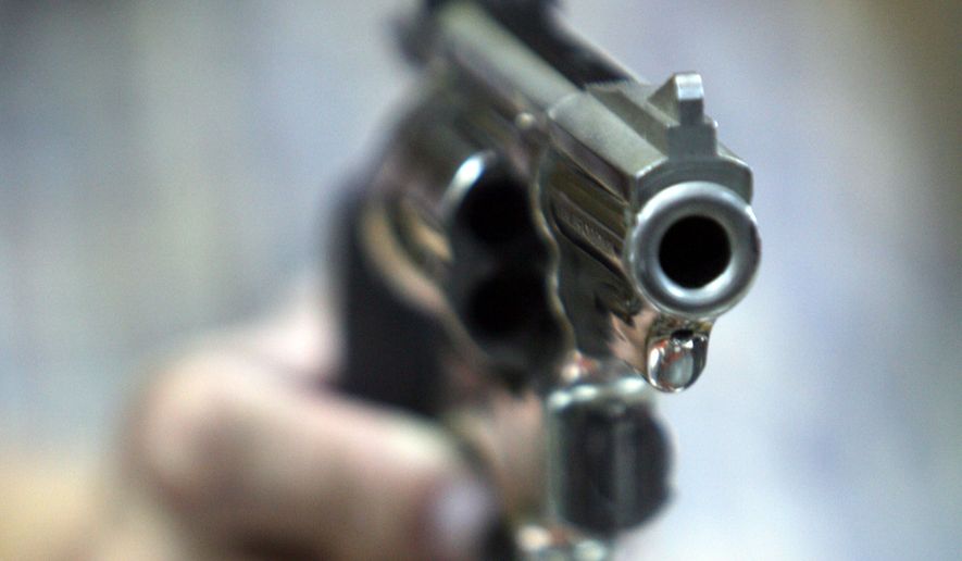 An employee at John Jovino Co. holds a revolver on Thursday, June 26, 2008 in New York. The U.S. Supreme Court ruled earlier in the day that Americans have a constitutional right to keep guns in their homes for self-defense - the justices' first major pronouncement on gun control in U.S. history. (AP Photo/Seth Wenig)