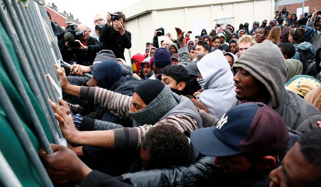 Seeking asylum: Migrants and activists scuffle with police after authorities started to clear out makeshift camps in Calais, France on the English Channel on May 28, 2014. Officials blame a British-French pact for burdening the city with immigrants seeking British asylum. (Associated Press) **FILE**