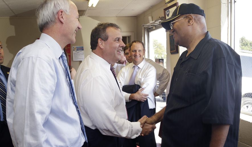 Republican candidate for Arkansas governor Asa Hutchinson, far left, watches as New Jersey Gov. Chris Christie, second from left, campaigns for Hutchinson at Lindsey’s Barbecue in North Little Rock, Ark., Wednesday, Aug. 27, 2014. (AP Photo/Danny Johnston)