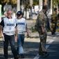 Members of the OSCE examine the scene of a shelling in the town of Donetsk, eastern Ukraine, Wednesday, Aug. 27, 2014. The Obama administration accused Russia on Wednesday of orchestrating a new military campaign in Ukraine, helping rebel forces expand their fight in the country&#x27;s east and sending tanks, rocket launchers and armored vehicles toward communities elsewhere. (AP Photo/Mstislav Chernov)