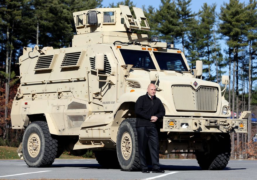 Warren County Undersheriff Shawn Lamouree poses in front of the department's mine-resistant ambush protected vehicle in Queensbury, New York. The vehicles are among the biggest pieces of equipment that the Defense Department is giving to law enforcement agencies.