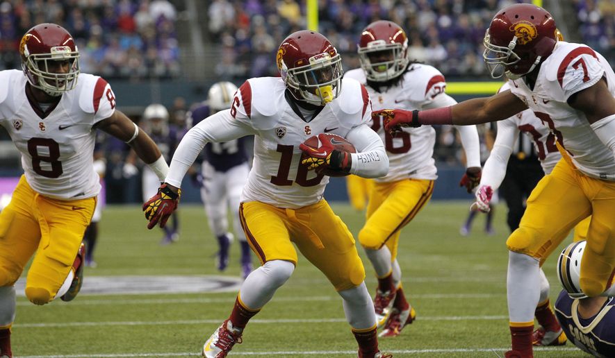 Southern California&#39;s Anthony Brown, center, runs in the ball for a touchdown after blocking a punt by Washington&#39;s Travis Coons during the first half of an NCAA college football game Saturday, Oct. 13, 2012, in Seattle. (AP Photo/Elaine Thompson)