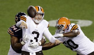 Cleveland Browns quarterback Rex Grossman (3) throws an incomplete pass after being hit by Chicago Bears defensive end Cornelius Washington (94) in the third quarter of a preseason NFL football game Thursday, Aug. 28, 2014, in Cleveland. (AP Photo/Tony Dejak)