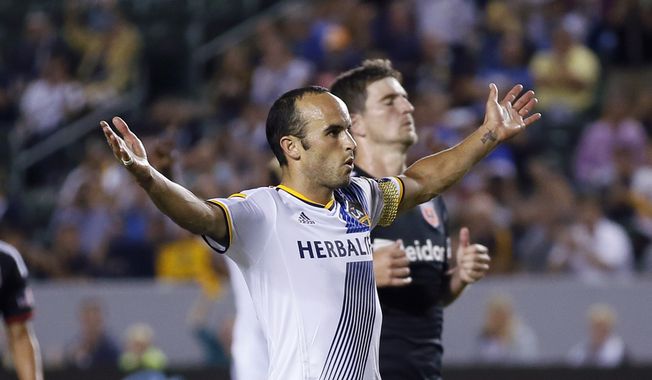 Los Angeles Galaxy&#x27;s Landon Donovan celebrates after scoring a goal on a penalty kick, next to D.C. United&#x27;s Bobby Boswell during the second half of an MLS soccer match Wednesday, Aug. 27, 2014, in Carson, Calif. The Galaxy won 4-1. (AP Photo/Danny Moloshok)