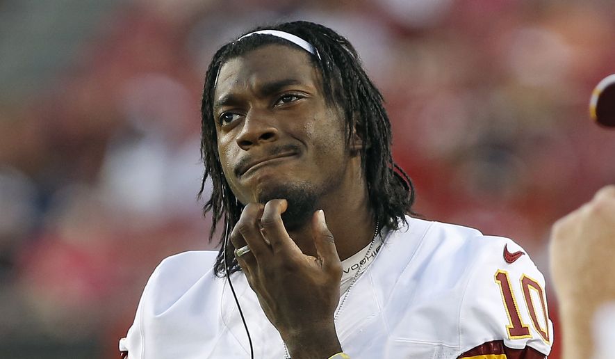 Washington Redskins quarterback Robert Griffin III (10) watches from the sidelines during the first quarter of an NFL preseason football game against the Tampa Bay Buccaneers Thursday, Aug. 28, 2014, in Tampa, Fla. (AP Photo/Brian Blanco) 