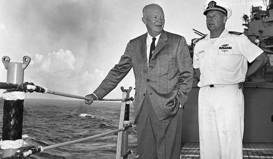 President Dwight Eisenhower stands with Capt. John A. Maurer, skipper of the cruiser St. Paul, as the warship moves along the Southern tip of Formosa during trip from Manila. (AP Photo, file)
