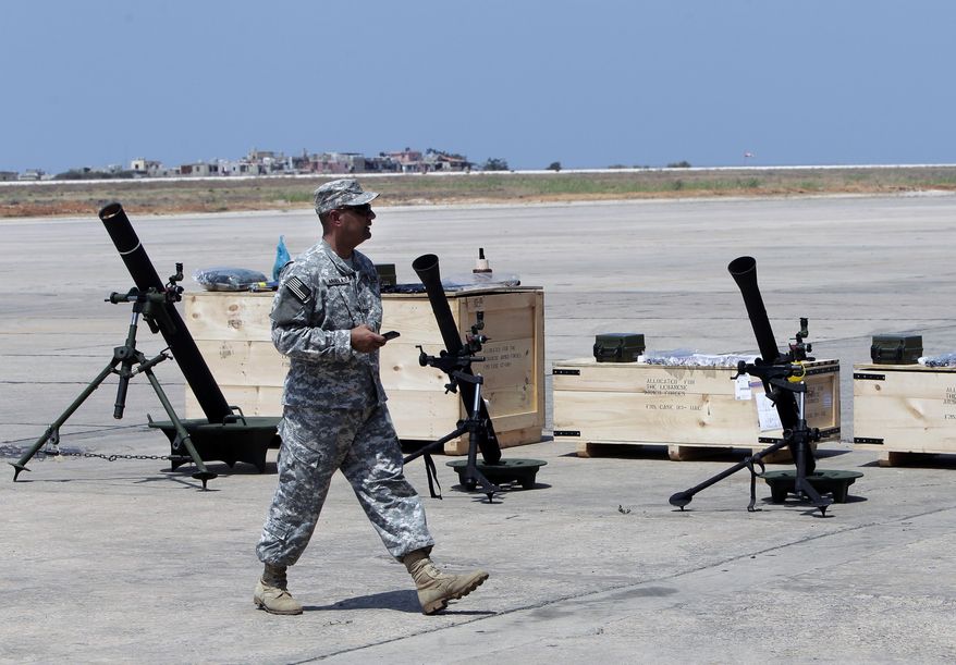 A U.S. soldier walks past mortars at the Rafik Hariri International Airport in Beirut, Lebanon, Friday, Aug. 29, 2014. The United States has delivered the first shipment of weapons to Lebanon to help bolster its military as it faces a growing threat from Islamic militants amid the fallout from neighboring Syria's civil war. (AP Photo/Bilal Hussein)