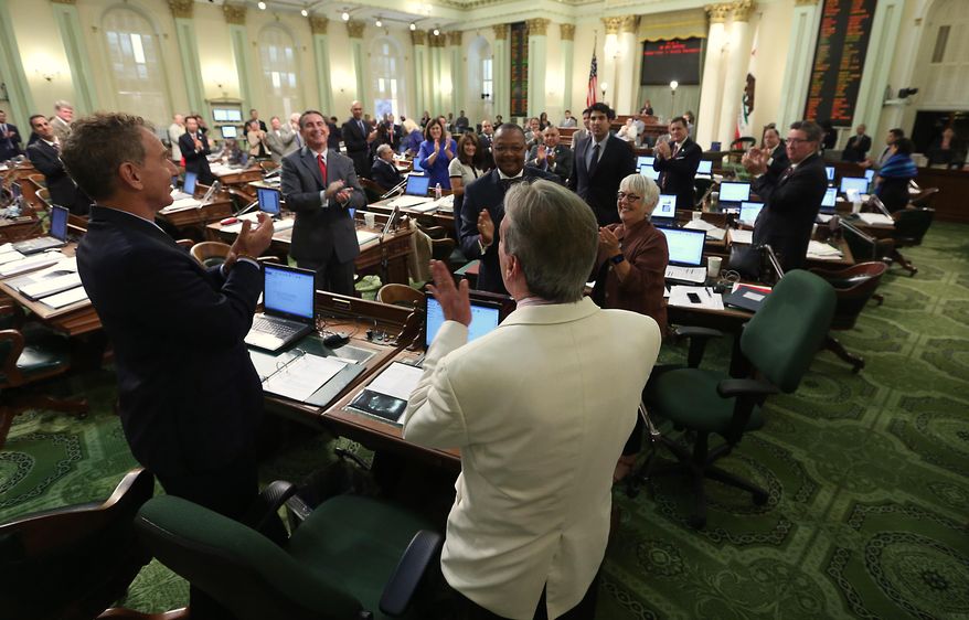 Assemblyman Tom Ammiano, D-San Francisco, foreground, receives a standing ovation from lawmakers after he presented his last bill before the Assembly at the Capitol in Sacramento, Calif., Friday, Aug. 29, 2014. By a 45-17 vote the Assembly approved Ammianno's bill, AB885, which will allow juries in criminal cases to consider whether prosecutors intentionally withheld evidence when deliberating a verdict. This was Ammiano's last piece of legislation as he is leaving office due to term limits.(AP Photo/Rich Pedroncelli)