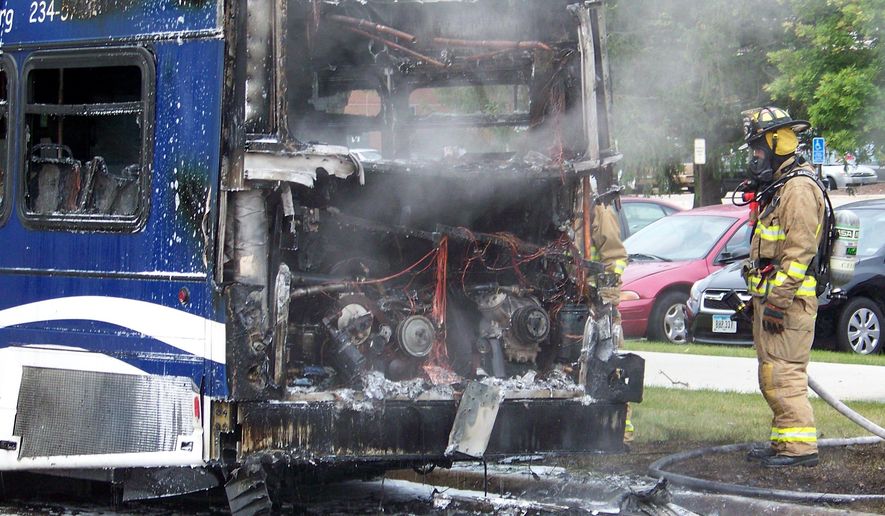 In this photo taken on Thursday, Aug. 28, 2014, firefighters work to extinguish a Metropolitan Transit Authority bus that caught fire near the University of Northern Iowa campus in Cedar Falls, Iowa. No one was injured.(AP Photo/Cedar Rapids Gazette, Jeff Reinitz)