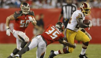 Washington Redskins Silas Redd (24) elludes Tampa Bay Buccaneers defenders Dane Fletcher (50) and Marc Anthony (35) during a NFL preseason football game Thursday, Aug. 28, 2014 in Tampa, Fla. (AP Photo/Steve Nesius) 