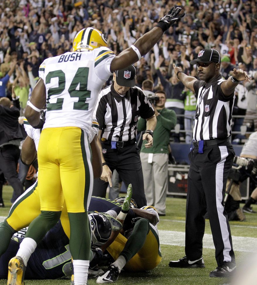 FILE - In this Sept. 24, 2012, file photo, officials decide on a call for the final play of the game as Green Bay Packers' Jarrett Bush (24) reacts in the second half of an NFL football game between the Packers and Seattle Seahawks in Seattle. It's been nearly two full years since the Packers and Seahawks met in the regular season, a game that forever became known as the "Fail Mary," for the disputed touchdown on the final play. Both teams say that result has no relevance to Thursday night's, Sept. 4, 2014, season opener, even if no one will ever forget the play.(AP Photo/Stephen Brashear, File)