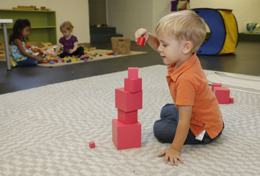 In this Tuesday, Aug. 5, 2014 photo, Three-year old Dash B. plays with wooden blocks at The Green House, an eco-friendly pre-school in Oklahoma City. There are currently about 80 nature-based preschools nationwide, up from 19 in 2009, said Christy Merrick, director of the Natural Start Alliance, which is part of the North American Association for Environmental Education. But she noted that numerous other preschools employ some sort of eco-friendly approach. (AP Photo/Sue Ogrocki)