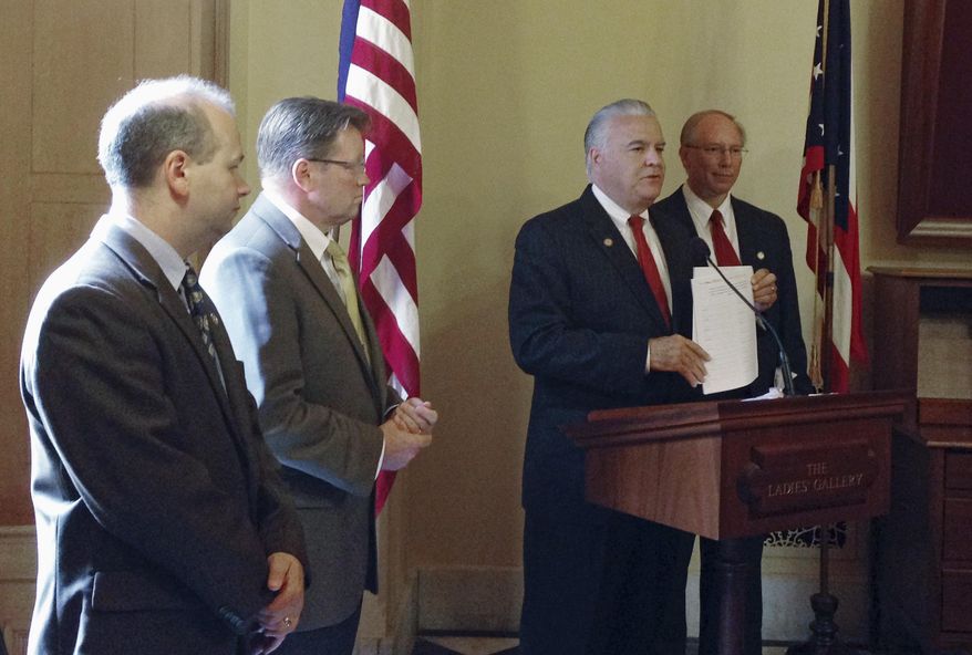 Republican State Rep. Matt Lynch, second from right, announces plans to force the Ohio House to vote on a bill that would require voters to show photo identification at the polls in Columbus, Ohio on Tuesday, Sept. 2, 2014. State lawmakers are on summer break, and it is uncertain whether the effort will be successful. (AP Photo/Ann Sanner)