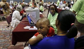 Former Revel Hotel Casino employees, Fatuma Kamara holds her 11-month-old baby Mussa as she gets help from Kristanna Brown as she files for unemployment benefits Wednesday, Sept. 3, 2014, in Atlantic City, N.J. (AP Photo/Mel Evans) **FILE**