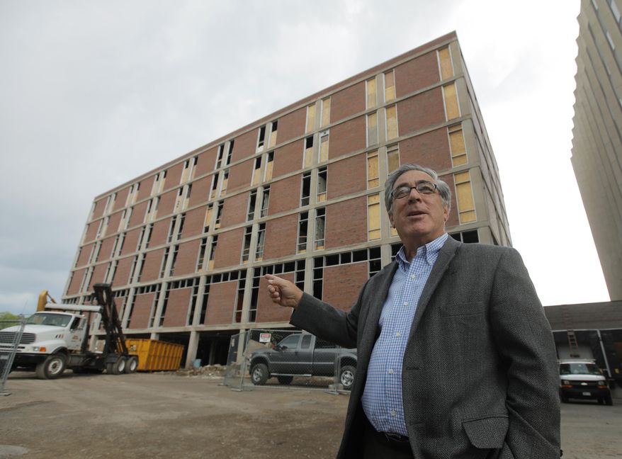 In this June 24, 2010 photo, developer Larry Glazer gestures toward a building to be demolished on Alexander Street in Rochester, N.Y. Glazer and wife, Jane, were aboard their small plane, which took off from the Greater Rochester International Airport, as it flew 1,700 miles down the East Coast on Friday, Sept. 5, 2014, before finally crashing off the coast of Jamaica. (AP Photo/Democrat & Chronicle, Carlos Ortiz) MAGS OUT; NO SALES