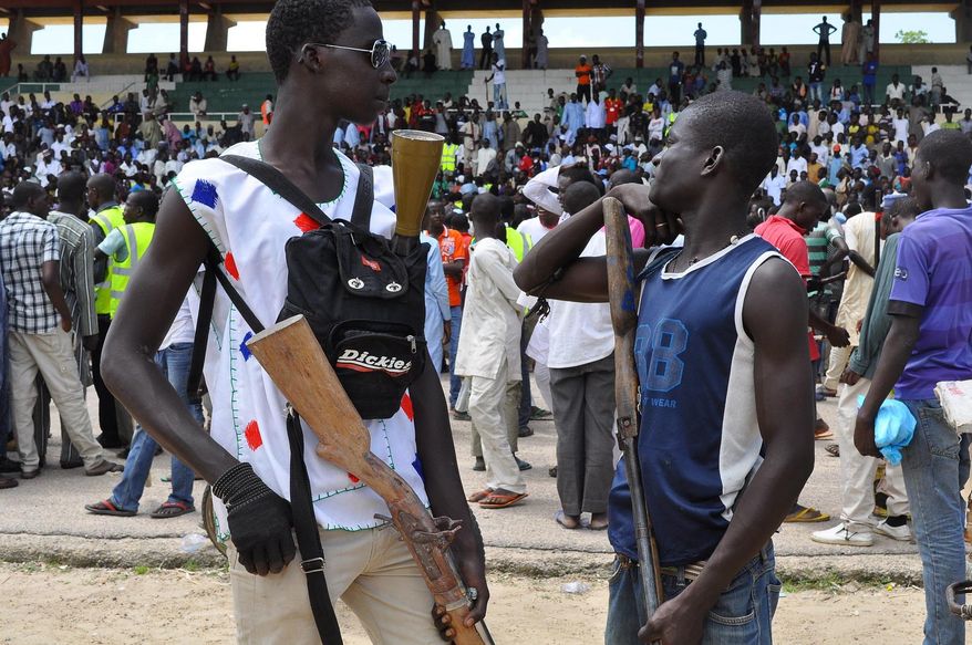 Vigilante and local hunters armed with guns gather outside the Emir's palace in Maiduguri, Nigeria, Thursday, Sept. 4, 2014. The United States is preparing to launch a "major" border security program to help Nigeria and its neighbors combat the increasing number and scope of attacks by Islamic extremists, a senior U.S. official for Africa said Thursday. Nigerian insurgents have begun attacking villages in neighboring Cameroon and have been seizing land in northeast Nigeria where they proclaimed an Islamic caliphate. (AP Photo/Jossy Ola)
