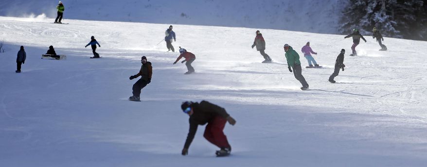 FILE - In this Nov. 23, 2013, file photo, skiers and snowboarders make their way down a trail at Park City Mountain Resort, in Park City, Utah. A long-running court battle between two ski industry titans is putting the upcoming season in jeopardy at one of Utah's largest resorts. A Utah judge is expected to decide Friday, Sept. 5, 2014, how much Park City Mountain Resort must pay to cover back rent and court costs so it can stay open through April 2015. If the price tag is too high, the lifts could stand idle when the season opens in less than three months. (AP Photo/Rick Bowmer, File)
