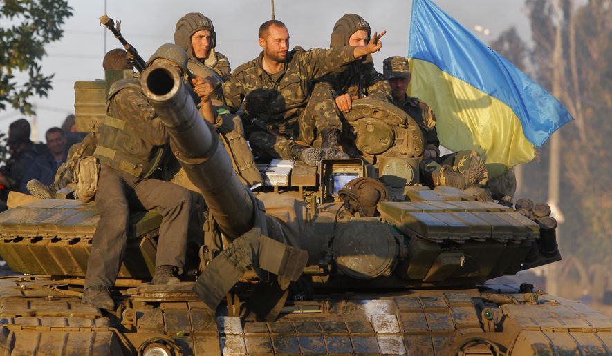 Soldiers of Ukrainian army ride on a tank in the port city of Mariupol, southeastern Ukraine, Friday, Sept. 5, 2014. The Ukrainian president declared a cease-fire Friday to end nearly five months of fighting in the nation&#39;s east after his representatives reached a deal with the Russian-backed rebels at peace talks in Minsk. (AP Photo/Sergei Grits)