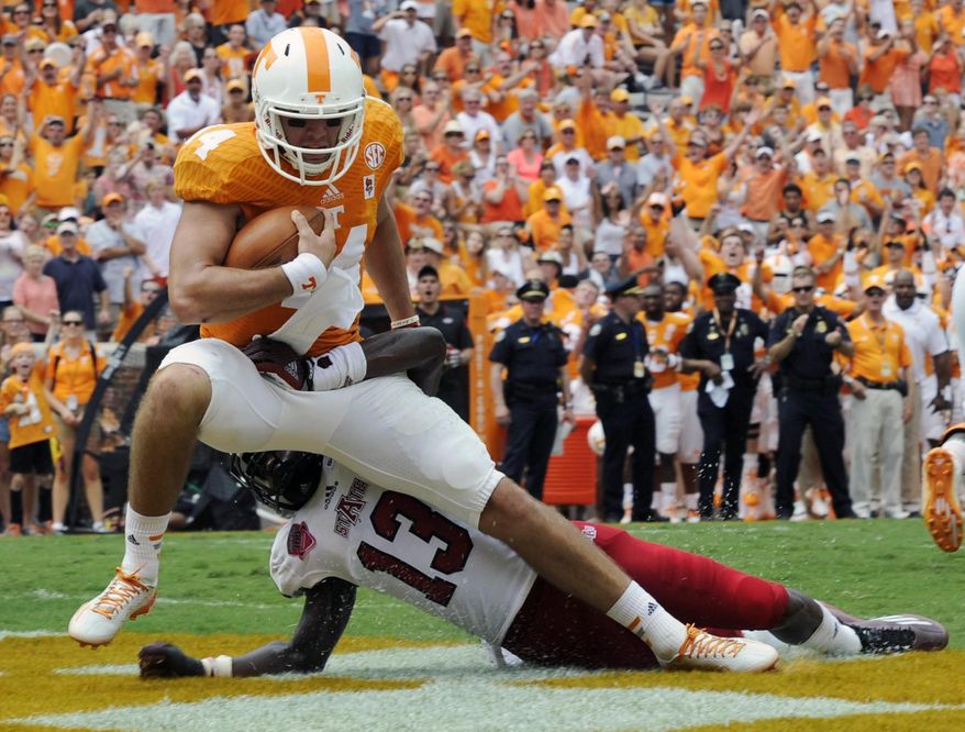 Tennessee quarterback Justin Worley (14) drags Arkansas State defensive back Charleston Girley (13) as he runs for a touchdown during an NCAA college football game Saturday, Sept. 6, 2014, in Knoxville, Tenn. (AP Photo/Knoxville News Sentinel, Amy Smotherman Burgess)