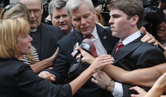 FILE - In this Sept. 4, 2014 file photo, former Virginia Gov. Bob McDonnell, center, is mobbed by media as he gets into a car with his son, Bobby, right, after he and his wife, former first lady Maureen McDonnell, were convicted on multiple counts of corruption at Federal Court in Richmond, Va. Now that the guilty verdicts on public corruption are in, attention turns to the McDonnells&#39; Jan. 6 sentencing and subsequent appeal. (AP Photo/Steve Helber, File)