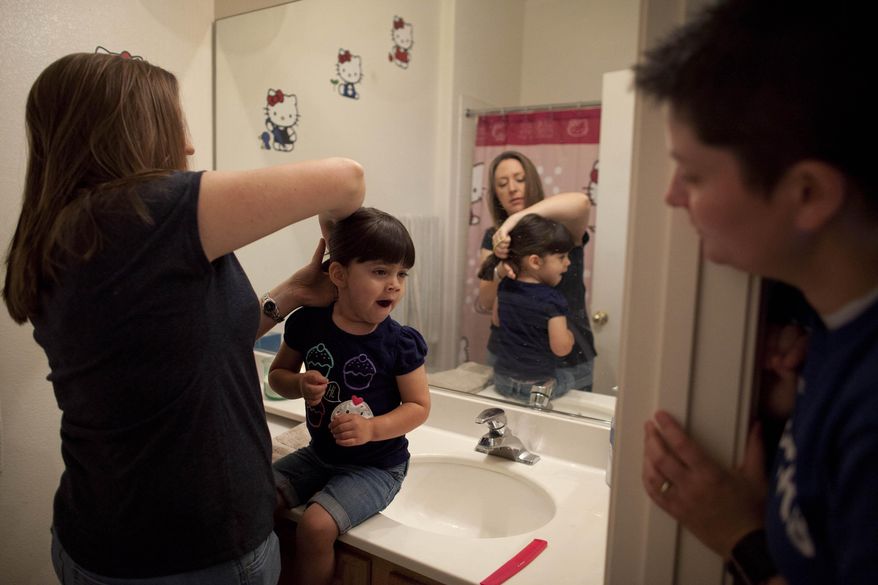 FILE - In this April 29, 2012 file photo, Megan Lanz, left, combs her 3-year-old daughter, Jordan's hair, as partner Sara Geiger watches before the three leave for a picnic in a park, in Las Vegas. The same-sex marriage debate returns Monday Sept. 8, 2014, to the same San Francisco federal appeals court that has already issued two significant rulings in support of gay weddings. The 9th U.S. Circuit Court of Appeals will consider separate lawsuits stemming from gay marriage bans in Idaho, Nevada and Hawaii. So far, 19 states and Washington D.C. now allow gay marriages even though the U.S. Supreme Court has yet to directly rule on whether states can impose bans. (AP Photo/Julie Jacobson, file)