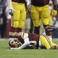 Washington Redskins&#39; Robert Griffin III (10) lies on the turf after he was sacked for a loss by Houston Texans&#39; J.J. Watt during the third quarter of an NFL football game against the Washington Redskins, Sunday, Sept. 7, 2014, in Houston. (AP Photo/Patric Schneider)