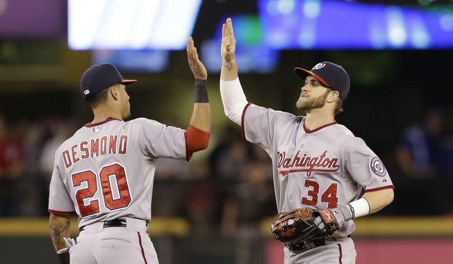 Washington Nationals&#x27; Ian Desmond (20) and Bryce Harper share congratulations after the Nationals defeated the Seattle Mariners 8-3 in a baseball game Friday, Aug. 29, 2014, in Seattle. (AP Photo/Elaine Thompson)
