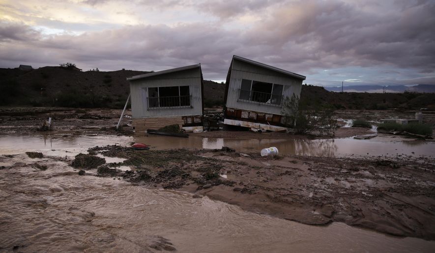 Receding flood water surrounds a home in Moapa, Nev., Monday, Sept. 8, 2014. Flooding throughout the area damaged homes and roads. (AP Photo/John Locher)