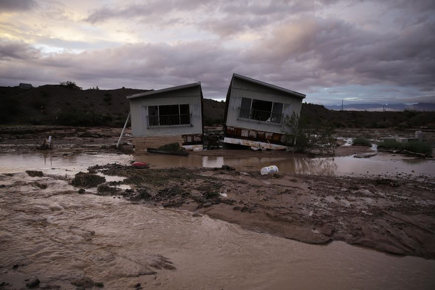 Receding flood water surrounds a home in Moapa, Nev., Monday, Sept. 8, 2014. Flooding throughout the area damaged homes and roads. (AP Photo/John Locher)
