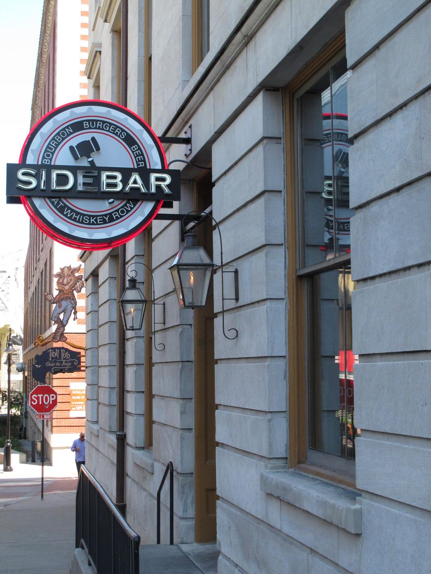 This Sept. 5, 2014 photo shows the exterior of Sidebar at Whiskey Row on the Urban Bourbon Trail in Louisville, Ky. The establishment, in the city that touts itself as the gateway to bourbon country, offer bourbon-inspired menu items and fully stocked bars that include hard-to-find bourbons. (AP Photo/Bruce Schreiner)