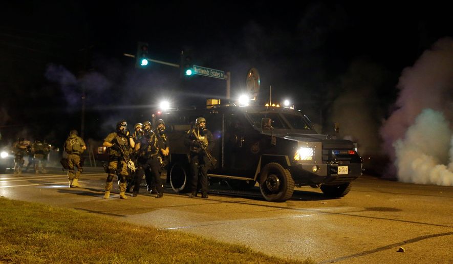 Police in riot gear work to disperse protesters in Ferguson, Missouri. Federal agencies acknowledged they don't track how the automatic weapons and armored trucks are used by police, the Defense and Homeland Security departments testified to Congress. (Associated Press)