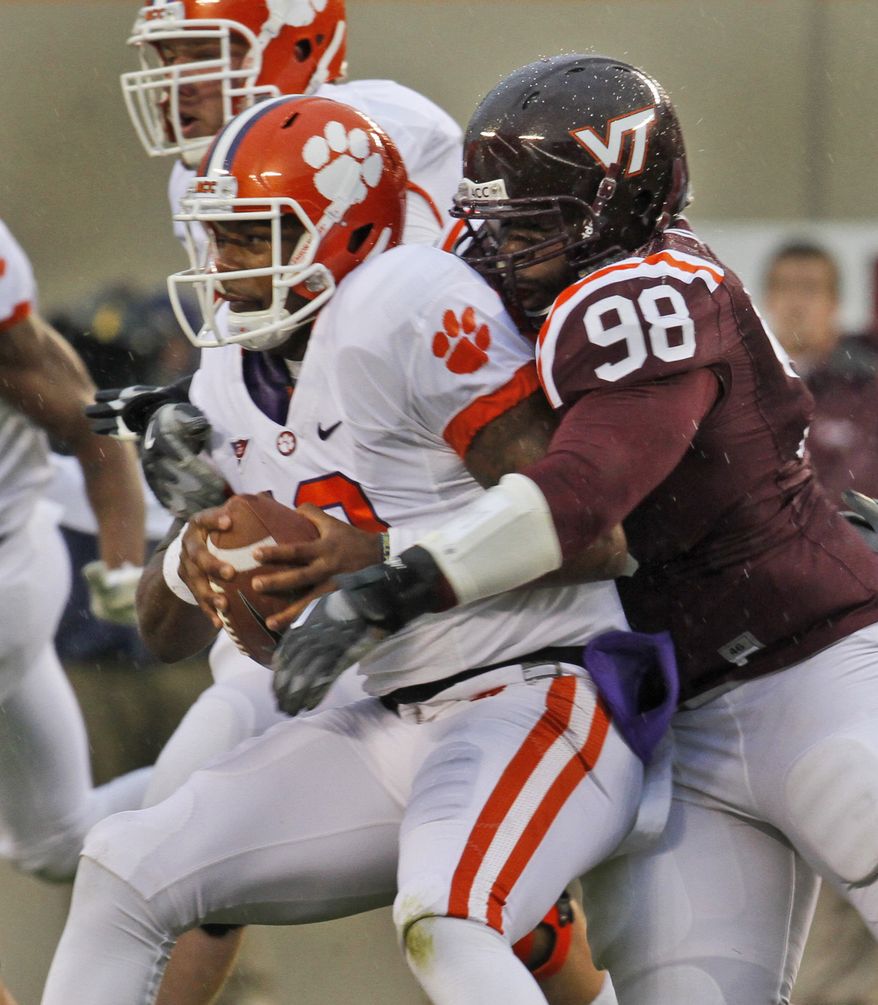 Clemson quarterback Tajh Boyd ,left, is sacked by Virginia Tech defensive tackle Derrick Hopkins (98) during the first half of an NCAA college football game at Lane Stadium in Blacksburg, Va., Saturday, Oct. 1, 2011. (AP Photo/Steve Helber)