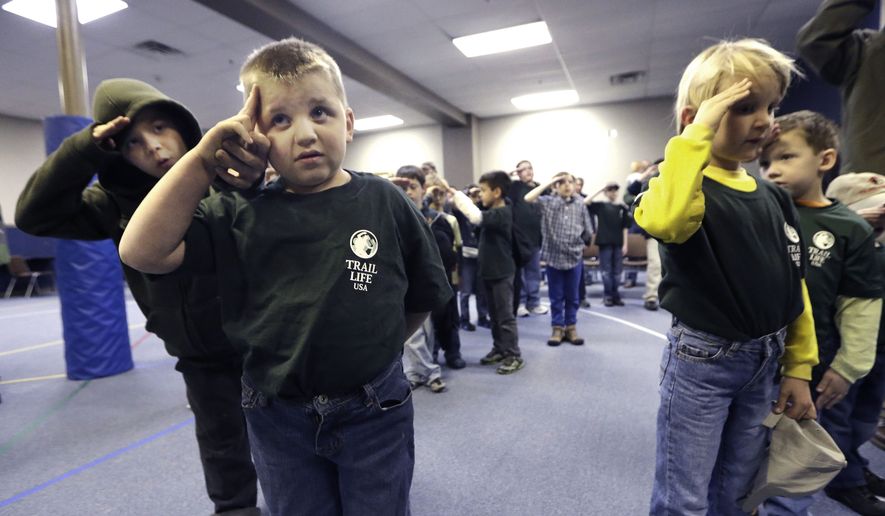 In this Tuesday, Feb. 4, 2014 photo, Trail Life member Adrian McCade, 7, second from left, gets direction on hand placement for the salute from his older brother Jack McCade, 8, during a group meeting in North Richland Hills, Texas. John Stemberger, an Orlando, Fla. lawyer who led the opposition to the Boy Scouts of America&#x27;s May 2013 vote to accept openly gay youth, went on to found Trail Life. (AP Photo/LM Otero)