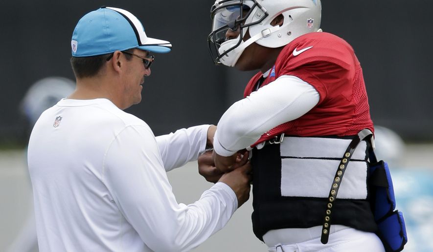 Carolina Panthers head coach Ron Rivera, left, helps Cam Newton, right, adjust his protective flak jacket during an NFL football practice in Charlotte, N.C., Wednesday, Sept. 10, 2014. Rivera said Monday he expected Newton to start against the Detroit Lions on Sunday after missing the season opener at Tampa Bay with a rib injury. (AP Photo/Chuck Burton)