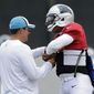 Carolina Panthers head coach Ron Rivera, left, helps Cam Newton, right, adjust his protective flak jacket during an NFL football practice in Charlotte, N.C., Wednesday, Sept. 10, 2014. Rivera said Monday he expected Newton to start against the Detroit Lions on Sunday after missing the season opener at Tampa Bay with a rib injury. (AP Photo/Chuck Burton)