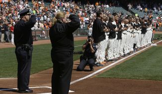 San Francisco Police Chief Greg Suhr, left and Fire Chief Joanne Hayes-White salute next to San Francisco Giants players who stand on the line to honor 9/11 during the national anthem before a baseball game against the Arizona Diamondbacks in San Francisco, Thursday, Sept. 11, 2014. (AP Photo/Jeff Chiu) ** FILE **