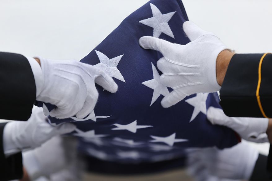An Army honor guard folds a flag from a casket during a memorial service and burial at Great Lakes National Cemetery in Holly Township, Mich., Thursday, Sept. 11, 2014. (AP Photo/Paul Sancya) ** FILE **