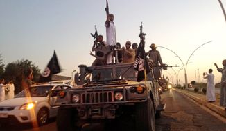 Fighters from the Islamic State group parade in an Iraqi security forces armored vehicle. Experts say defeating the group is more akin to what was required to beat al Qaeda in Iraq, which was founded in 2004 by Jordanian Abu Musab al-Zarqawi and subsequently led by the group&#39;s current chief, Abu Bakr al-Baghdadi, an Iraqi cleric. (Associated Press)