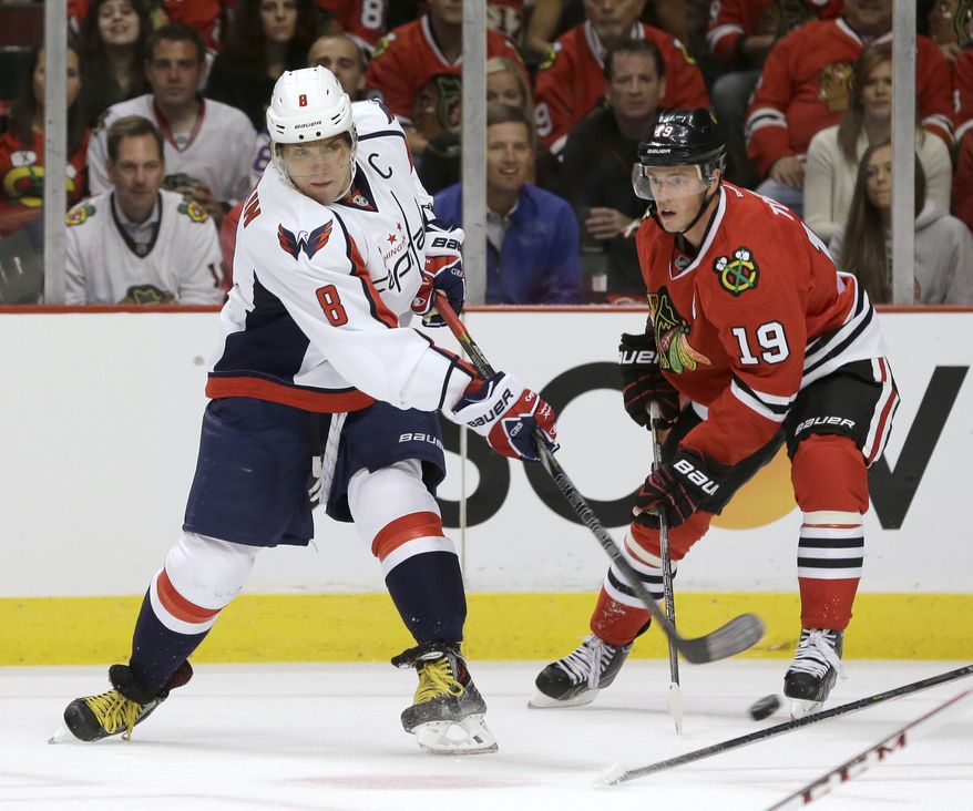 Washington Capitals right wing Alex Ovechkin (8) takes a shot past Chicago Blackhawks center Jonathan Toews (19) during the first period of an NHL hockey game Tuesday, Oct. 1, 2013, in Chicago. (AP Photo/Nam Y. Huh)