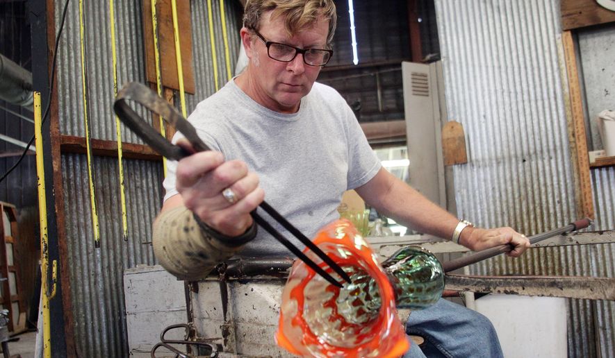 Artisan Donovan Garrett works on Blenko Glass Company's 2012 West Virginia Day piece in Milton, West Va. Free tours are offered at the Blenko glass factory, one of a number of free things to see and do around the state. (AP Photo/Sholten Singer, The Herald-Dispatch, File)