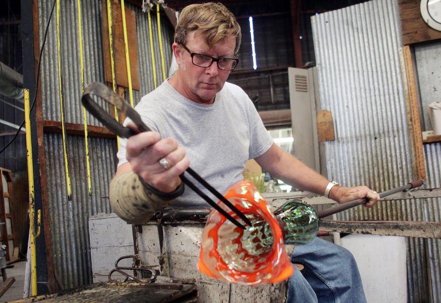Artisan Donovan Garrett works on Blenko Glass Company's 2012 West Virginia Day piece in Milton, West Va. Free tours are offered at the Blenko glass factory, one of a number of free things to see and do around the state. (AP Photo/Sholten Singer, The Herald-Dispatch, File)