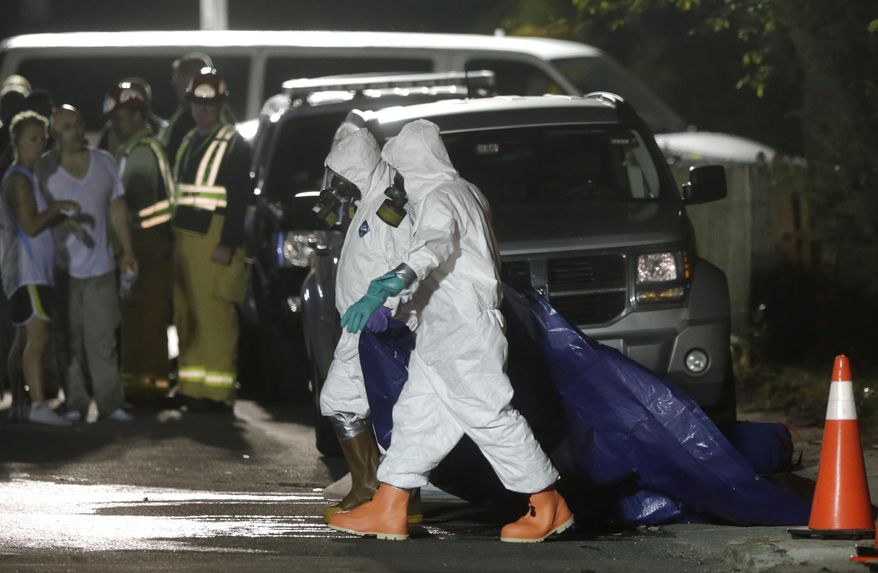 Investigators in protective clothing drag a tarp across the street in front of a house where a Massachusetts prosecutor said the bodies of three infants were found Thursday, Sept. 11, 2014, in Blackstone, Mass. Worcester County District Attorney Joseph Early Jr. said Thursday authorities don't know when or how the babies died. (AP Photo/Steven Senne)