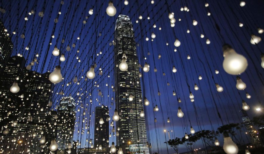 An artwork titled “Scattered Light,” created by American artist Jim Campbell, is lit at an exhibition in Hong Kong's Central district Thursday, Sept. 11, 2014. The installation that has a structure with 2,000 light bulbs was presented by Hong Kong Arts Development Council. (AP Photo/Vincent Yu)T