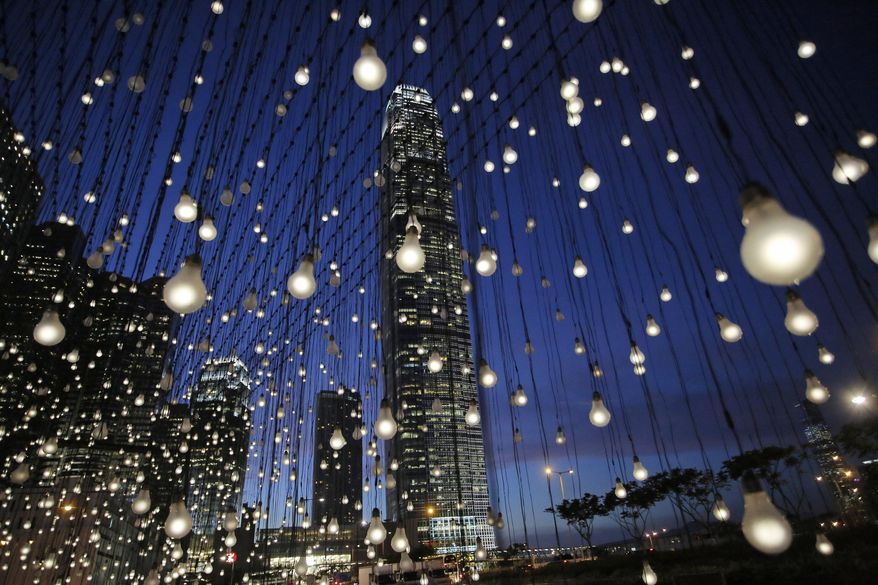 An artwork titled “Scattered Light,” created by American artist Jim Campbell, is lit at an exhibition in Hong Kong's Central district Thursday, Sept. 11, 2014. The installation that has a structure with 2,000 light bulbs was presented by Hong Kong Arts Development Council. (AP Photo/Vincent Yu)T