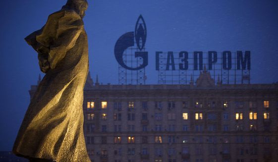 In this March 4, 2014 file photo, a monument to Ukrainian poet and writer Taras Shevchenko is silhouetted against an apartment building with a sign advertising Russia&#39;s natural gas giant Gazprom, in Moscow, Russia. A senior administration official said Tuesday that Russia&#39;s largest banks could be the next targets of sweeping sanctions if Moscow further invades Ukraine. (AP Photo/Alexander Zemlianichenko, file)