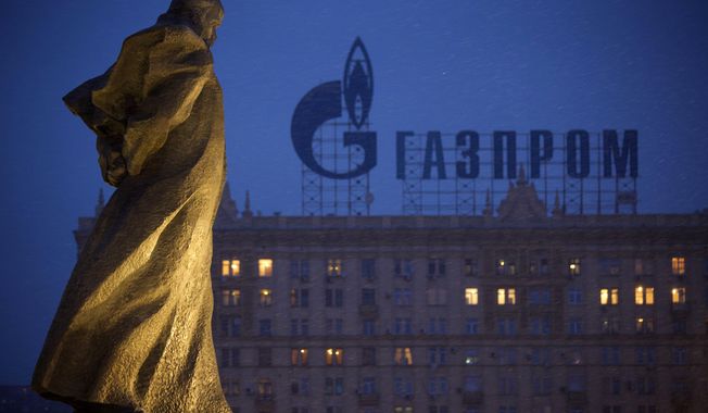 In this March 4, 2014 file photo, a monument to Ukrainian poet and writer Taras Shevchenko is silhouetted against an apartment building with a sign advertising Russia&#x27;s natural gas giant Gazprom, in Moscow, Russia. A senior administration official said Tuesday that Russia&#x27;s largest banks could be the next targets of sweeping sanctions if Moscow further invades Ukraine. (AP Photo/Alexander Zemlianichenko, file)