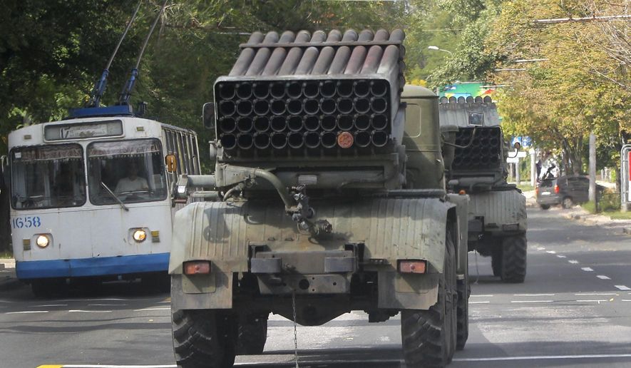 Pro-Russian rebels drive multiple rocket launchers "Grad" (means "hail") in the town of Donetsk, eastern Ukraine, Thursday, Sept. 11, 2014. Two volleys of rocket fire rang out in Ukraine's eastern, rebel-held city of Donetsk, underscoring the difficulties of enforcing a cease-fire almost a week after it was signed. The city council of Donetsk confirmed in a statement Thursday there had been multiple explosions during the morning, but reported no casualties. ( AP Photo)