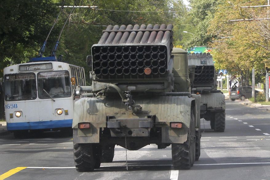 Pro-Russian rebels drive multiple rocket launchers "Grad" (means "hail") in the town of Donetsk, eastern Ukraine, Thursday, Sept. 11, 2014. Two volleys of rocket fire rang out in Ukraine's eastern, rebel-held city of Donetsk, underscoring the difficulties of enforcing a cease-fire almost a week after it was signed. The city council of Donetsk confirmed in a statement Thursday there had been multiple explosions during the morning, but reported no casualties. ( AP Photo)