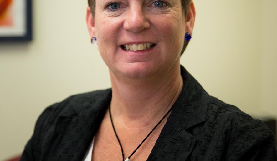 Navigator program specialist Cindy Balliet poses for a portrait in her office at the Community Action Partnership building on Sunday, Aug. 15, 2014 in Lincoln, Neb. Balliet came to the job without deep political convictions about the new national health insurance plan. She knew insurance. She'd sold insurance. She knew some people had trouble getting health insurance. (AP Photo/The Journal-Star, Dan Little) LOCAL TELEVISION OUT; KOLN-TV OUT; KGIN-TV OUT; KLKN-TV OUT