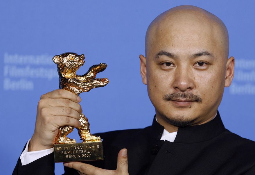 File - In this Feb. 17, 2007 file photo, Chinese film director Wang Quan'an shows his Golden Bear award for the best movie at the 57th International Film Festival Berlin 'Berlinale' in Berlin for his movie "Tuyas Marriage." Beijing police say they have detained Wang on a charge of prostitution. Police said in a statement Monday, Sept. 15, 2014 that Wang was found with a suspected prostitute several days ago in a Beijing apartment and paid the woman 800 yuan ($130) for the service. Police say Wang engaged in prostitution for three nights in a row. (AP Photo/Markus Schreiber, Pool, File)